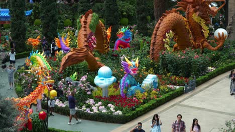 Cúpula-De-Flores-En-Los-Jardines-Junto-A-La-Bahía-Durante-El-Año-Nuevo-Lunar-Con-Decoración-De-Esculturas-Con-Temas-De-Dragones-En-Exhibición-En-El-Invernadero,-Toma-Estática-Que-Captura-A-Las-Personas-Que-Visitan-El-Invernadero-De-Vidrio-Más-Grande-Del-Mundo