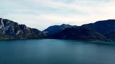 Ruhige-Luftaufnahme-Eines-Türkisfarbenen-Sees,-Umgeben-Von-üppigen-Grünen-Bergen