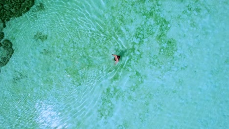 Tourist-Swimming-at-Mai-Ngam-Beach-with-a-Top-Down-Aerial-View-Over-Turquoise-Waters-at-Mu-Ko-Surin-National-Park,-Surin-Island,-Thailand