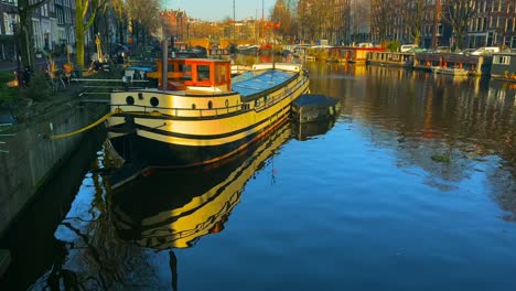 Houseboat-lights-idyllic-in-sunlight-Dutch-canal-in-the-center-of-Amsterdam