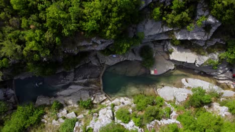 Vista-Panorámica-De-Las-Piscinas-Naturales-De-Roca-De-Papingo,-La-Gente-Nada-Y-Disfruta,-Ovires-De-Rogovo-En-Grecia