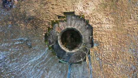 Aerial-top-down-ascend-view-over-abandoned-military-observation-tower-on-hill