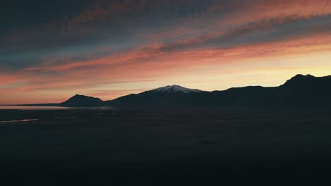 Increíble-Y-Hermoso-Dron-Y-Toma-Aérea-Del-Sol-Poniente-Contra-Una-Hermosa-Cadena-Montañosa-Cubierta-De-Nieve