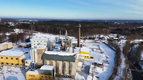 Luftaufnahme-Eines-Industriegebäudes-Mit-Waldhintergrund-Im-Winter,-Silute,-Litauen