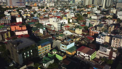 Drone-shot-over-vibrant-dwellings,-golden-hour-in-Makati-city,-Manila,-Philippines
