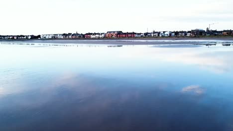 Eine-Niedrige-Drohnenaufnahme-über-Der-Ruhigen-Irischen-See-In-Richtung-Skerries-Beach,-Irland