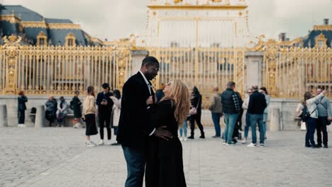 Pareja-De-Raza-Mixta-Abrazándose-Y-Coqueteando-Frente-A-La-Famosa-Puerta-Principal-Dorada-Del-Honor-Del-Castillo-De-Versalles---Slomowtion-Cinematográfico