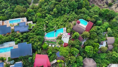 Pool-party-in-luxury-hotel-in-tropical-jungle-of-Thailand,-aerial-view