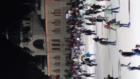 Vista-Vertical-De-Personas-Patinando-En-La-Pista-De-Hielo-Del-Parque-De-La-Ciudad-En-Budapest,-Hungría