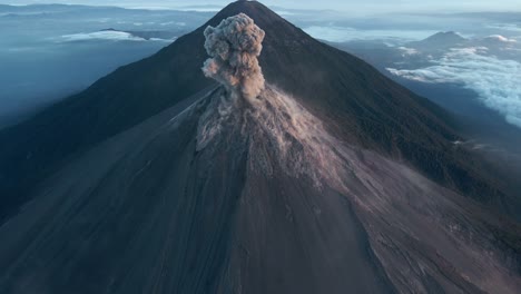 Cinematic-aerial-push-in-of-Fuego-volcano's-massive-eruption-with-dramatically-rising-ash-plume-and-Acatenango-volcano-with-campsites-visible-in-background