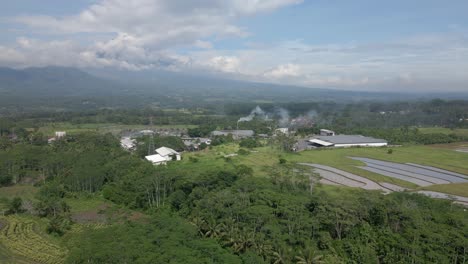 Drone-shot-of-industry-with-burning-fossil-fuels-in-the-middle-of-agricultural-field