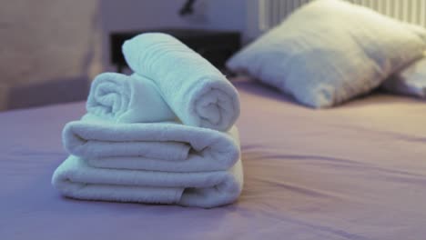 Neatly-Rolled-Towels-on-a-Cozy-Bed