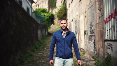 Porto,-Portugal,-February-10,-2024:-Tourist-man-walking-though-poor-neiborhood-narrow-alley-in-Porto-District,-Portugal