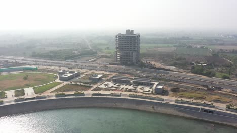 La-Cámara-De-Drones-Con-Vista-De-Drones-Del-Lago-Rajkot-Atal-Se-Está-Moviendo-Hacia-Arriba-Y-El-Trabajo-Del-Gran-Jardín-Y-El-Gran-Edificio-Están-En-Marcha