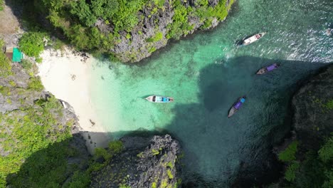 Longtail-boats-touring-tropical-Wang-Long-lagoon-in-Phi-phi-Thailand,-Aerial