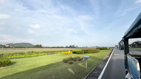 Open-door-transport-along-the-Koh-Samui-Island-Airport-during-a-sunny-day,-View-from-left-door-of-vehicle