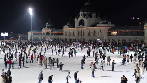 Gran-Multitud-De-Personas-Patinando-Sobre-Hielo-En-La-Popular-Pista-De-Hielo-Del-Parque-De-La-Ciudad,-Budapest,-Amplia