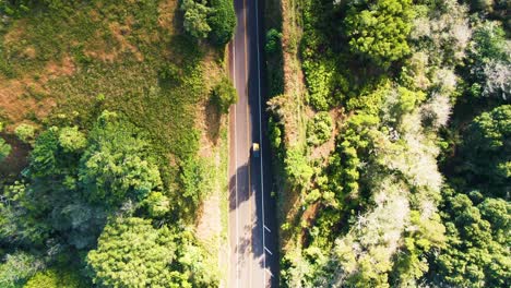 Aerial-birdseye-tracking-car-traveling-at-road-to-Hana,-revealing-city,-Maui,-Hawaii