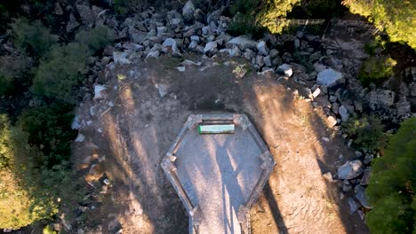 Top-down-drone-shot-of-a-manmade-platform-surrounded-by-green-woodland-Spain