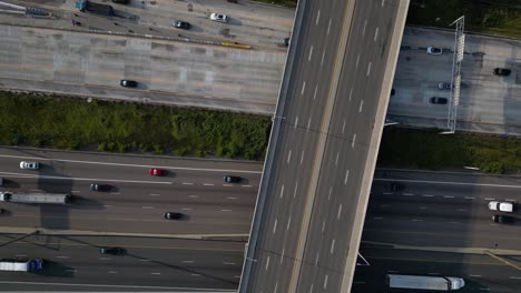 Top-down-of-freeway-road-construction-with-trucks-and-cars-driving-on-multi-level-highway