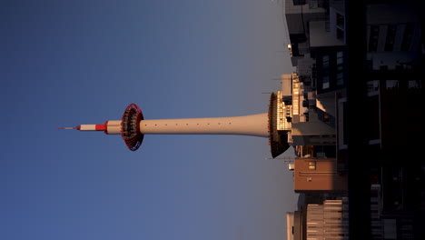 Das-Vertikale-Video-Zeigt-Den-Ikonischen-Kyoto-Tower-In-Tokio,-Japan-Und-Unterstreicht-Die-Architektonische-Pracht-Und-Urbane-Eleganz-Dieses-Hoch-Aufragenden-Bauwerks-Während-Des-Sonnenuntergangs-Zur-Goldenen-Stunde.
