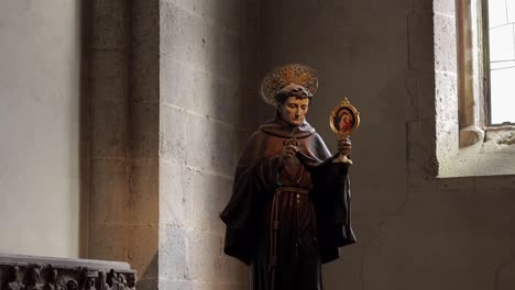 Window-lit-Statue-of-religious-Saint-inside-Catholic-Church-of-Gesu-Nuovo,