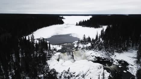 Pan-Down-Aerial-4K-Drone-In-Shot-of-environment-nature-Tourism-Travel-Landmark-frozen-winter-Pisew-Kwasitchewan-Falls-Waterfall-Provincial-Park-near-Thompson-Manitoba-Northern-Arctic-Canada-Landscape