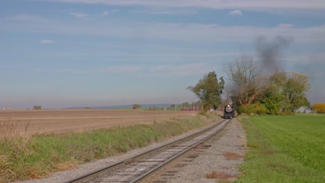 Ronks,-Pennsylvania,-USA,-October-26,-2023---A-Track-side-View-of-a-Stem-Passenger-Train-Approaching,-Blowing-Smoke-and-Steam-on-a-Sunny-Autumn-Day