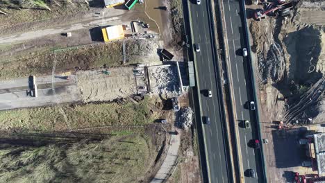 Static-drone-shot-of-a-construction-site-and-highway-next-to-eachtoher