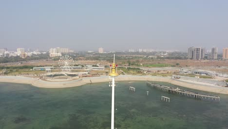 Going-towards-Rajkot-Atal-lake-drone-view-side-big-lake-is-visible-behind-it,-Rajkot-New-Race-Course,-Atal-Sarovar