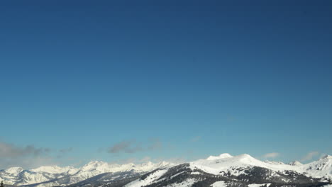 Opening-landscape-scene-top-of-Copper-Mountain-American-Flyer-lift-cinematic-pan-to-the-right-Vail-Pass-Gore-Range-Colorado-Rocky-Mountains-late-winter-early-morning-bluebird-fresh-snow-pan-down