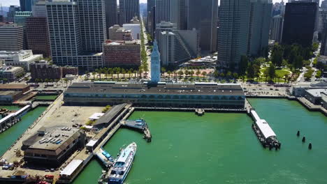 Vista-Aérea-Acercándose-Al-Edificio-Del-Ferry,-En-El-Soleado-Embarcadero,-San-Francisco