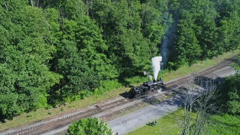 Luftaufnahme-Einer-Antiken-Shay-Dampflokomotive,-Die-An-Einem-Sonnigen-Sommermorgen-In-Zeitlupe-Rückwärts-Fährt,-Um-Sich-Einem-Bahnhof-Zu-Nähern