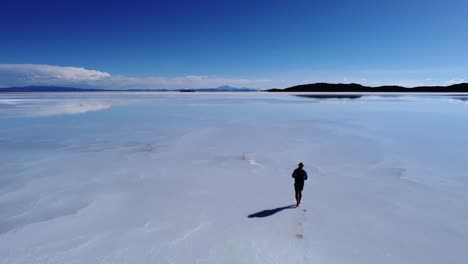 El-Hombre-Proyecta-Sombra-Sobre-La-Superficie-Del-Salar-De-Uyuni,-Antena-De-Bolivia