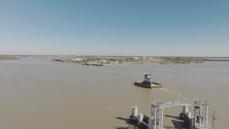 Una-Toma-Aérea-Del-Ferry-De-Lynchburg-Saliendo-Del-Campo-De-Batalla-De-San-Jacinto-Y-Cruzando-El-Canal-De-Navegación-De-Houston-Hasta-El-Muelle-En-Lynchburg,-Texas.