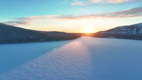 Pyha,-Finland---The-Sun-Shining-Over-a-Frozen-Lake---Aerial-Drone-Shot