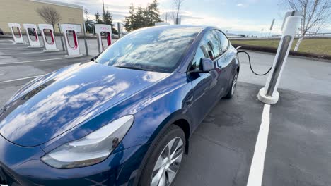 Vehículo-Eléctrico-Azul-Cargando-En-Un-Sobrealimentador-De-Tesla