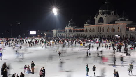 Timelapse-of-people-skating-at-night-at-City-Park-Ice-Rink,-Budapest,-wide-angle
