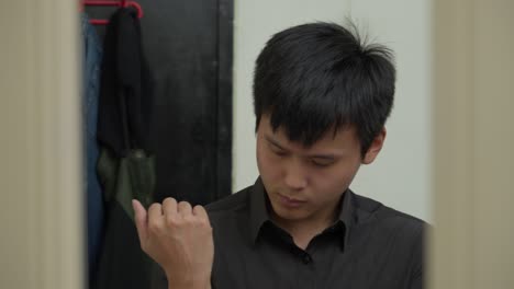 Asian-man-gets-ready-looking-at-self-in-mirror