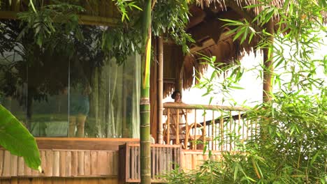 Woman-in-Eco-bamboo-hotel-resort-in-jungle-landscape,-static-view