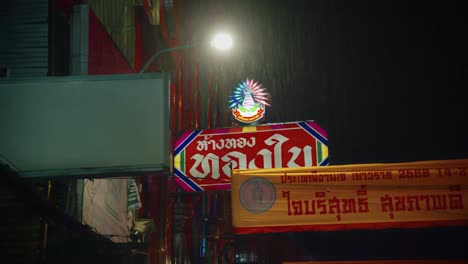Chinesische-Leuchtende-Zeichen-Im-Regen-Auf-Einer-Belebten-Straße-In-Bangkok
