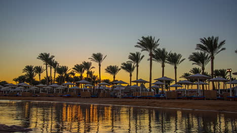 Beautiful-Sunset-Time-Lapse-into-Dusk-with-Palm-Trees-and-Resort-Umbrellas-at-Pickalbatros-Laguna-Vista-Hotel,-Sharm-El-Sheikh,-Egypt