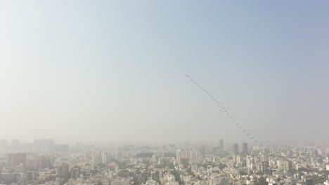 Vista-Aérea-De-Drones-Del-Festival-De-Cometas-De-Rajkot,-Donde-Se-Ven-Muchos-Edificios-Grandes-Y-Cometas-Grandes,-Hay-Muchas-Casas-Residenciales