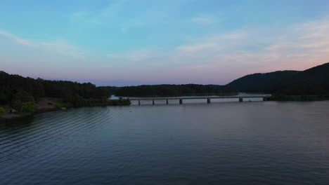 Forwards-fly-above-water-surface,-heading-towards-road-bridge-over-Lake-Allatoona