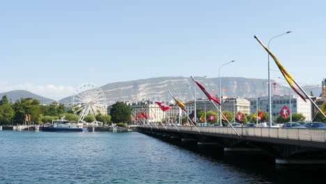 Atracción-De-La-Noria-Del-Lago-De-Ginebra-Junto-Al-Paisaje-De-La-Ciudad-De-Promenade-Du-Lac-Bajo-La-Montaña-Saleve