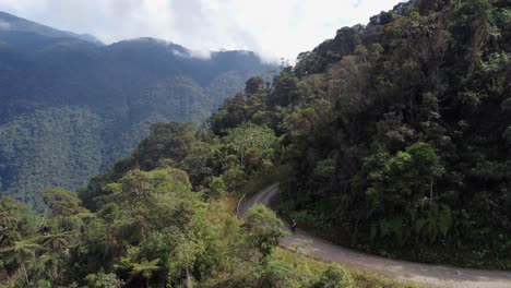 Los-Ciclistas-Descienden-Por-La-Mundialmente-Famosa-Carretera-De-Los-Yungas-En-Montañas-Escarpadas,-Bolivia