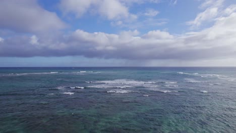 Drohnenaufnahmen-über-Den-Blauen,-Weißen-Wellen-Des-Kristallklaren-Wassers-Des-Pazifischen-Ozeans-Mit-Blauem-Himmel-Und-Bauschigen-Wolken