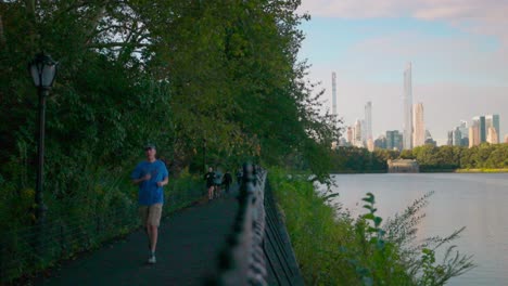 Morgenjogger-Laufen-Entlang-Des-Onassis-Reservoir-Pfades-Im-Central-Park-Mit-Stadtkulisse