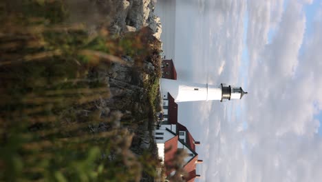 Vertical-static-shot-of-historic-Portland-Head-Light-near-rugged-ocean-shore