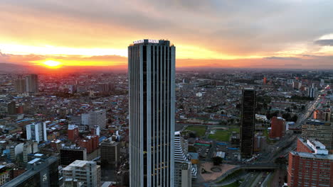 Aerial-view-rotating-away-from-the-Colpatria-tower,-sunset-in-Bogota-city,-Colombia